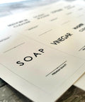 Close-up of waterproof laundry room labels for containers and cabinets featuring modern cleaning labels for easy organization.