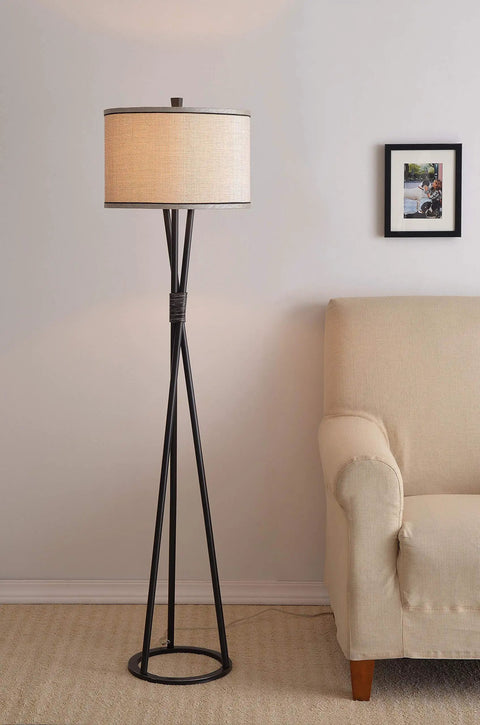 Mariah Floor Lamp With Black Finish And Silver Highlight next to beige sofa, 60 inch tall with Silver Fabric Drum Shade in living room.