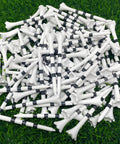 Pile of Three And A Quarter Inch White Golf Tees With Black Stripes Pack Of 50 Durable Plastic Tees With Six Prong Cup on grass