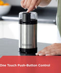 One Touch Coffee And Spice Grinder With Stainless Steel Blades And Bowl Two Thirds Cup Capacity Powerful 150 Watt Motor Quick Even Grinds For Coffee Beans Herbs Grains And Spices Easy Push Button Control showing hand using push-button on a kitchen counter