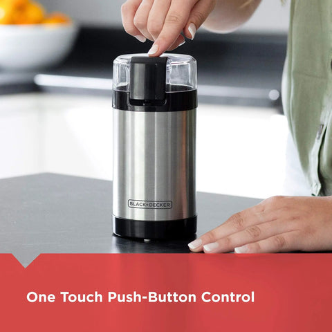 One Touch Coffee And Spice Grinder With Stainless Steel Blades And Bowl Two Thirds Cup Capacity Powerful 150 Watt Motor Quick Even Grinds For Coffee Beans Herbs Grains And Spices Easy Push Button Control showing hand using push-button on a kitchen counter