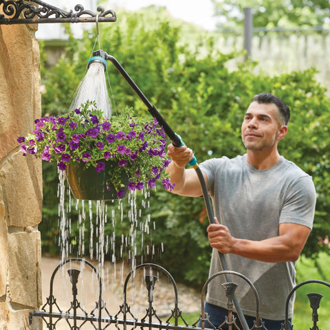 Man using Heavy Duty Swivel Connect Watering Wand Hose Sprayer With Five Spray Patterns for garden hanging basket