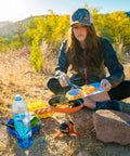 Person using Summit Skillet Nonstick Camping Cookware For Backpacking Stoves outdoors to cook with fresh ingredients.