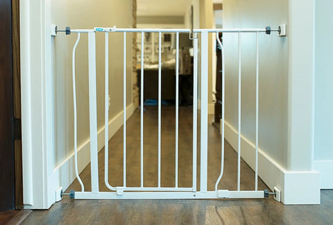 White pressure-mounted baby gate with smallest wall gate protector for stairs and doorways, flat top and bottom, 4 pack, hallway view.