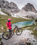 Mountain biker with a front mountain bike fender facing a lake and mountains on an enduro trail. Focus keyword visible.