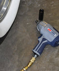 Half Inch Pneumatic Impact Wrench With 750 Ft Lbs Torque Three Speed Regulator shown near car wheel for lug nut removal