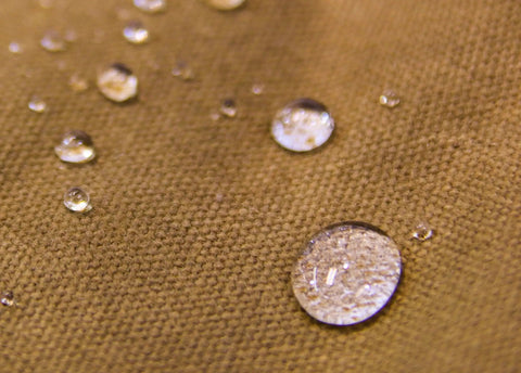 Close-up of water droplets on heavy duty waxed canvas, illustrating water resistance of Waxed Canvas Zipper Pouch Set.