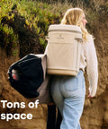 Carryout Cooler Backpack With All Day Cold Insulation And Portable Soft Build Trail And Park Friendly Features An Ergonomic Strap System 22 Liter Capacity In Shale Gray on a woman, carrying on a hike.