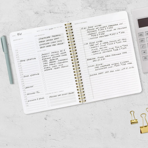 Open Daily Planner With Hourly Schedule Spiral Notepad For Easy Tasking And Appointment Organization beside calculator and pen