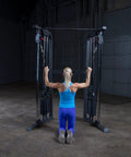 Person using Top Shelf Dual Stack Cable Crossover Machine For Home And Commercial Gyms with blue outfit, focusing on upper body workout.