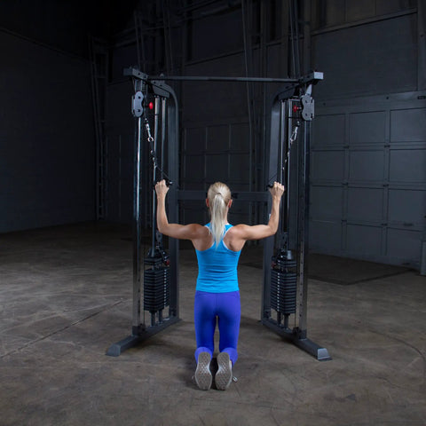 Person using Top Shelf Dual Stack Cable Crossover Machine For Home And Commercial Gyms with blue outfit, focusing on upper body workout.