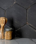 Retro Hex Nero Porcelain Tile For Floors And Walls Dope Hex Pattern Glazed Textured Finish with utensils on countertop.