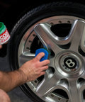 Applying Wheel Guard Max Coat Rim Sealant 8 Oz Dope Shine Ultra Durable Wheel Coating on a silver car wheel.