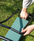 Person folding Garden Kneeler Seat Bench Dual-Mode With Heavy-Duty Steel Frame 330 Lb Capacity Removable EVA Padding on grass