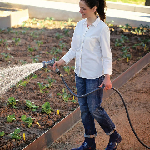 Person watering garden with Flexogen 5/8 Inch X 50 Ft Garden Hose Heavy Duty Water Hose Built To Last, Flexible And Kink Resistant