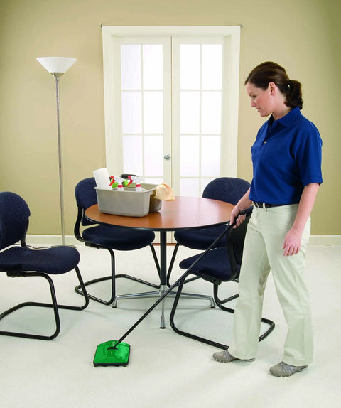 Woman using Compact Manual Carpet Sweeper For Hardwood And Tile Floors Abs Plastic Handle in a clean office space.
