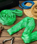 Four Pack Heavy Duty Polyester Endless Loop Round Lifting Straps For Hoists, Towing And Moving Furniture, Four Feet Long, Round Slings, Safe Rigging Gear, 10600 Lb Basket Capacity, 5300 Lb Vertical, 4200 Lb Choker, Green on a wooden surface.