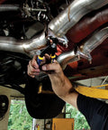 Mechanic using V Jaw 10 Inch Vise Grip Pliers With Press And Slide Button for Two Times Faster Jaw Adjustment on car exhaust pipe.