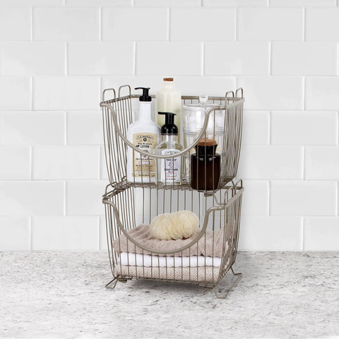 Small Stackable Wire Baskets For Pantry And Counter Organizer With Raised Feet And Handles Stacking Fruit Bin For Vegetables Potatoes Onions Storage In Satin Nickel Finish on counter filled with toiletries.