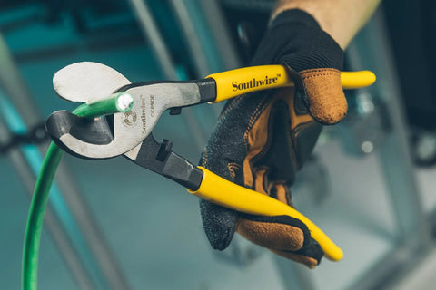 Tough Nine Inch Cable Cutter With Comfort Dipped Grips and Solid Forged Steel Arms cutting through green wire.
