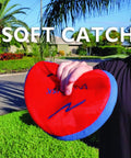 Person holding Soft Catch Flying Disc Red For Indoor Outdoor Fun, Safe Frisbee For Kids And Adults in a sunny yard.