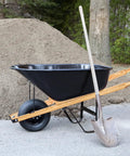 Wheelbarrow with 59 Inch Wood Wheelbarrow Handles Kit With Two Wedges, shown outdoors with a shovel; seal coat finish visible.