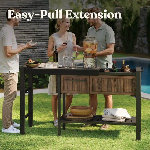 Extendable Outdoor Bar Cart With Hidden Cooler And Prep Surface set up for a backyard party with drinks and snacks