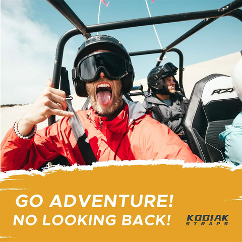 Person in a dune buggy wearing an orange jacket and helmet, with a focus on adventure, in a desert setting.