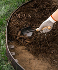 Killer 4 Inch No Dig Landscape Edging Kit With 75 Foot Black Plastic Edging Coil used in garden with hand placing mulch