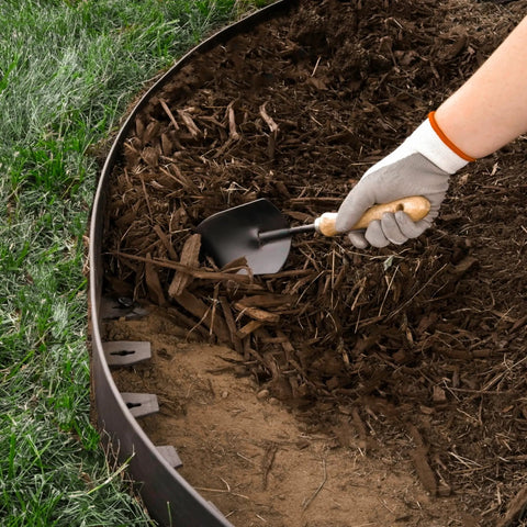 Killer 4 Inch No Dig Landscape Edging Kit With 75 Foot Black Plastic Edging Coil used in garden with hand placing mulch