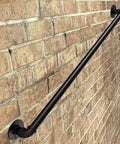 Badass Industrial Wrought Iron Stair Railing Kit Twenty Foot Wall Mount Banister Pipe Rail installed on brick wall.
