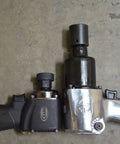Two impact wrenches on concrete floor, showcasing size comparison with 15-Piece 1/2 Inch Drive Low Profile Nano Impact Socket Set Metric Stubby Design.
