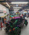Fresh Shop Grade Superflake Colorshift Basecoat Paint Gallon Ready To Spray With Slow Reducer Binder For Custom Rigs Delivering Dope Shiftin Shades on a custom purple vehicle in a garage workshop.