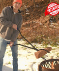 Man using 40 Inch Fire Poker And Log Grabber Set For Fire Pits Must Have Backyard Outdoor Indoor Bonfire Gear Rustproof Two Piece Campfire Tool With Ergonomic Rubber Handles for safe firewood movement in snow.