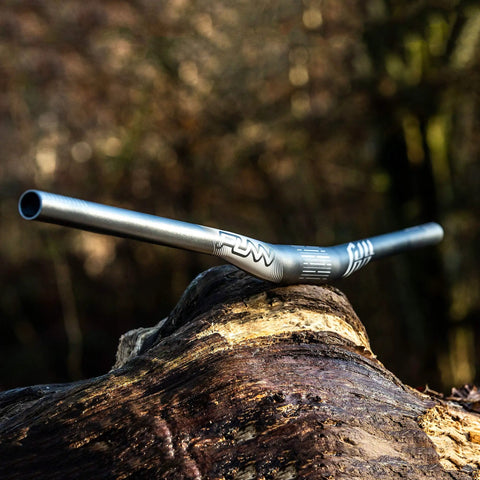 Full On Mountain Bike Handlebar, 31.8mm Clamp, 785mm Wide, 30mm Rise Beefy Alloy Riser Bar on rustic log, outdoor background