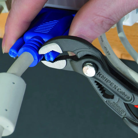 Cobra Water Pump Pliers, 5 Inch, Red, Adjustable Pliers With Self-Locking Teeth, 13 Positions, shown gripping a blue connector