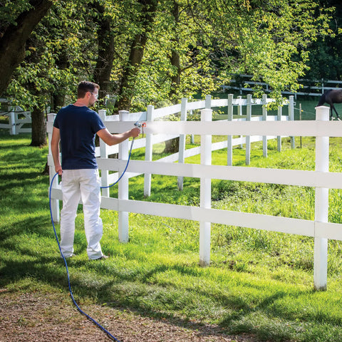 Heavy Duty Cart Paint Sprayer With Full Control Flow And RAC IV Switchtip For Thick Coatings Knocking Out Big Rental Jobs Without Breaking A Sweat, man spraying a fence outdoors.