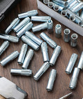 100 Pcs 3/8-16 Concrete Anchors Zinc Plated Carbon Steel Drop-In Anchors scattered on a wooden surface
