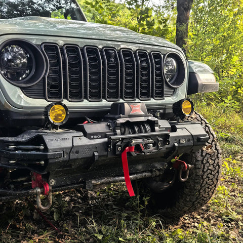 13,500 Pound Recovery Winch With 1/2 Inch Synthetic Rope For SUVs Trucks Jeeps And Off Road Recovery Heavy Duty 12V Electric Winch With High Torque Motor Dark Gray Built For Tough Trails Mud And Snow Recovery. Front view on Jeep bumper
