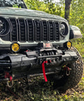 XYCLE 12000 Lb Electric Winch With Synthetic Rope mounted on a Jeep, designed for 4x4 offroad towing in rugged terrain.