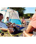 People enjoying a campsite with Space Saving Outdoor Camp Furniture Set With Chair, Cot, And Table Carry Bag Included Compact 3 In 1 Gear