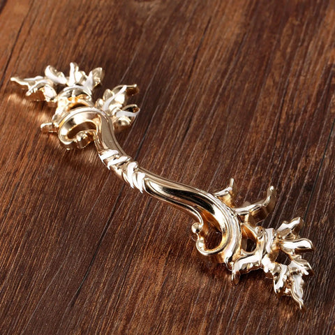 Gold Antique Dresser Handles Set Vintage French Provincial Style Cabinet Pulls for nightstands and dressers on wood surface.