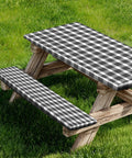 Elastic Edge Picnic Table Cover And Bench Covers Set For Outdoor Use Waterproof And Oil Resistant 96x30 inch table cover and 96x12 inch bench covers in black and white on a wooden picnic table in a garden.