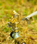 Heavy Duty Brass Impact Sprinklers Deliver Sick Durability, Adjustable Zero To Three Sixty Rotation For Huge Yard And Patio Watering, Rock Solid Build With Premium Nozzles, Fits Half Inch Pipe, Makes Your Landscape Look Fly, Reliable Four Piece Set. Close-up of sprinkler head spraying water.