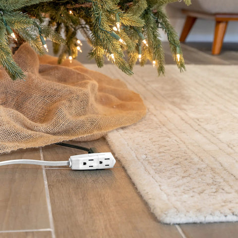 Heavy Duty Three Outlet Flat Extension Cord 3 Feet Long Grounded Power Cable With Secure Three Prong Plugs For Home Office Setup And Sleek Under Desk Layout under Christmas tree with soft beige rug.