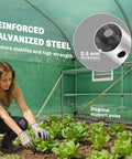 Person tending plants inside Walk In Tunnel Greenhouse With Shelves And Mesh Door For Easy Plant Care Great For Weekend Green Thumbs Outdoor Greenhouse With Two Tier Racks Windows PE Cover Perfect For Patio Garden.