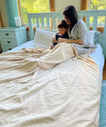 Mother and child under Ultra Cozy EMF Shielding Bed Blanket For Full Body Coverage Mega Large Faraday Blanket With Organic Cotton Silver Lining