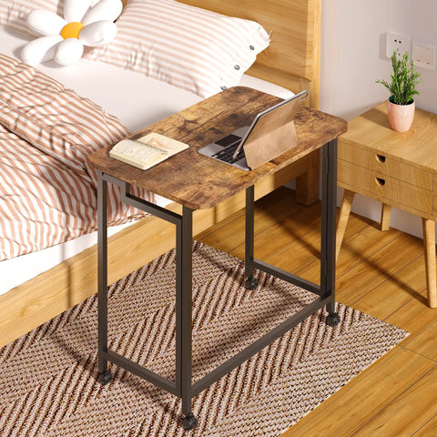 Folding Rolling Computer Desk For Small Spaces, Portable Laptop Cart On Wheels in Rustic Brown and Black finish by a bed