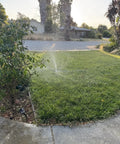 Heavy Duty Metal 3-Arm Rotating Sprinkler With Wheeled Base in action watering small yard with 360 degree coverage