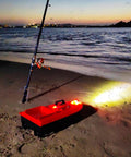 High Speed RC Saltwater Bait Boat For Beach Fishing With Waterproof Hull And GPS Auto Return on night beach with fishing rod.